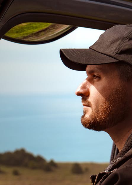 A man driving a truck and looking out into the distance